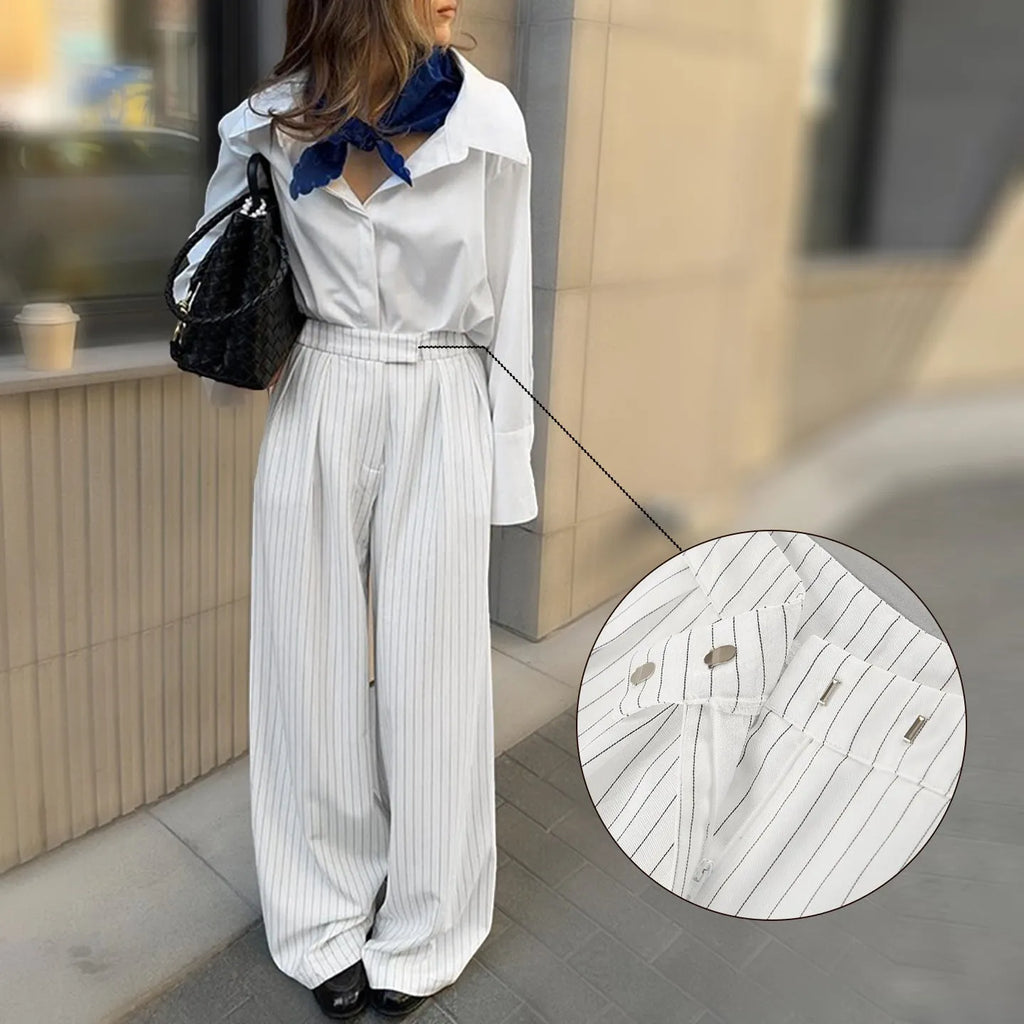 White striped wide-leg women's trousers with a front zip on a hanger.