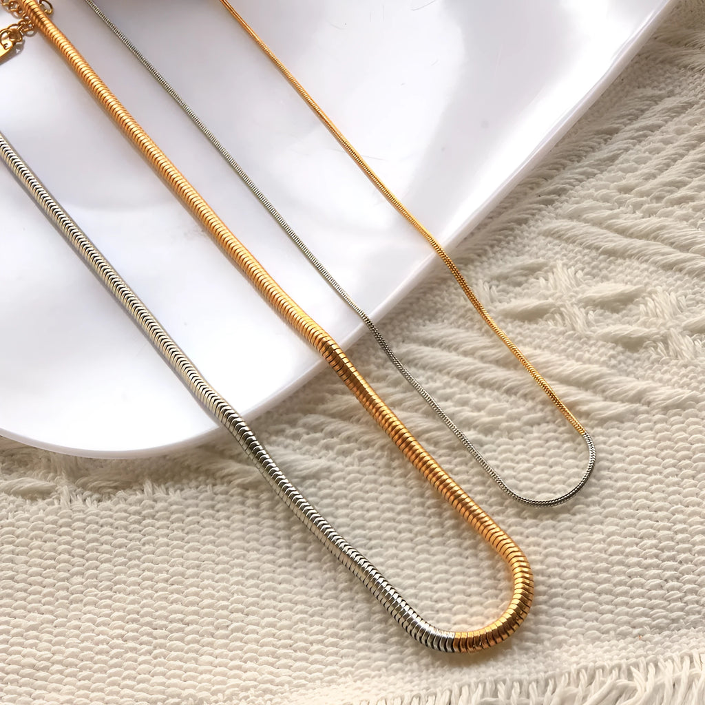 Close-up of a women's golden snake bone chain necklace with 3mm thick geometric stainless steel links.