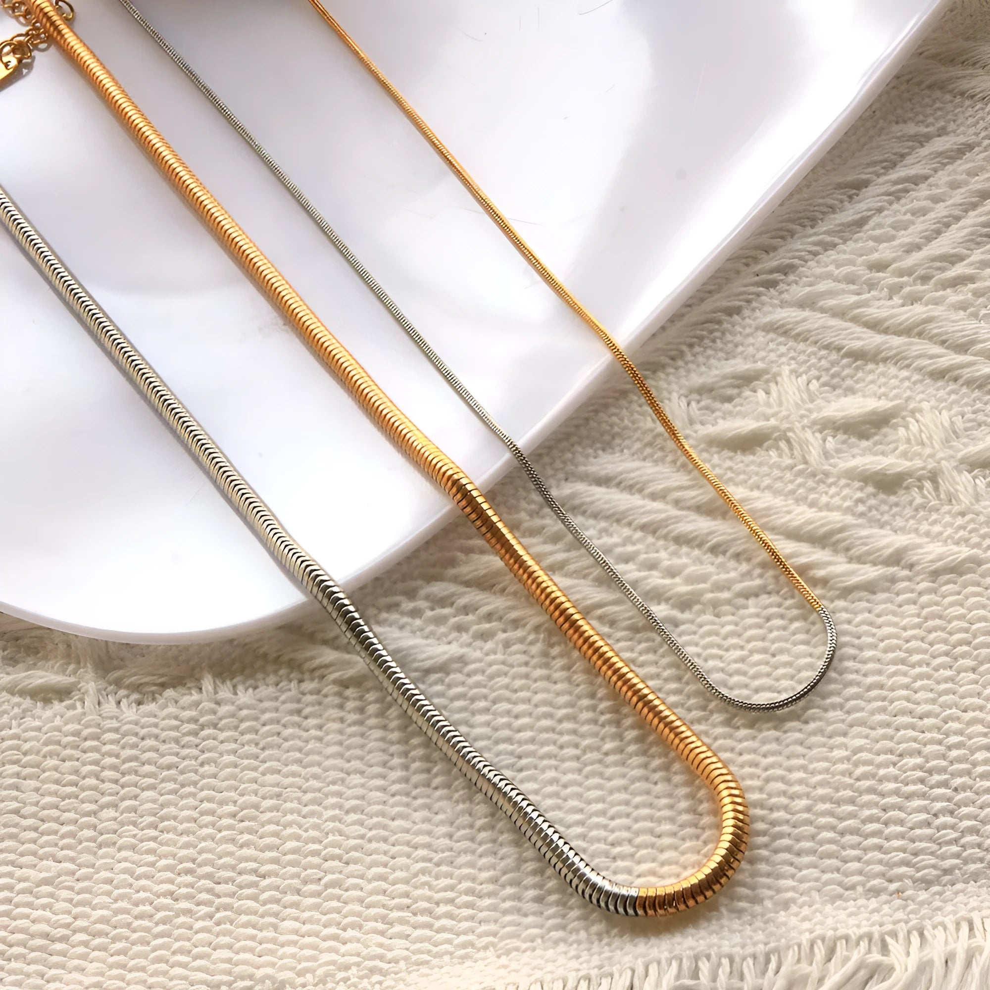Close-up of a women's golden snake bone chain necklace with 3mm thick geometric stainless steel links.
