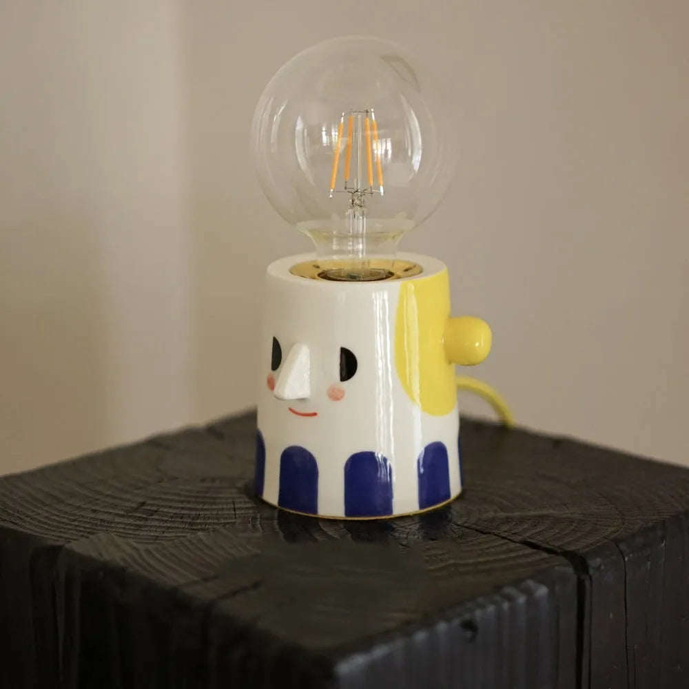 Handmade ceramic table lamp with a white spherical shade on a solid ceramic base, showcasing its simple design.
