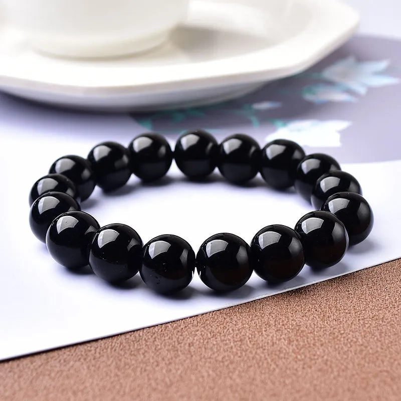 Geometric glass bead bracelet in obsidian, amethyst, citrine, or white crystal on a white background.