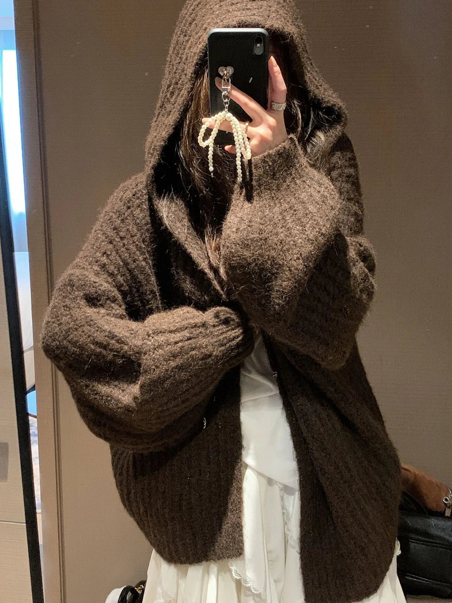 A woman's loose-fitting, hooded sweater cardigan in a solid colour, shown with regular sleeves.