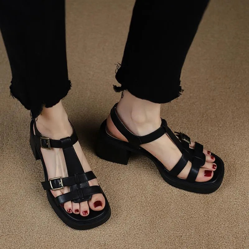 Women's black retro sandals with a chunky heel, platform, and T-shaped buckle fastening.