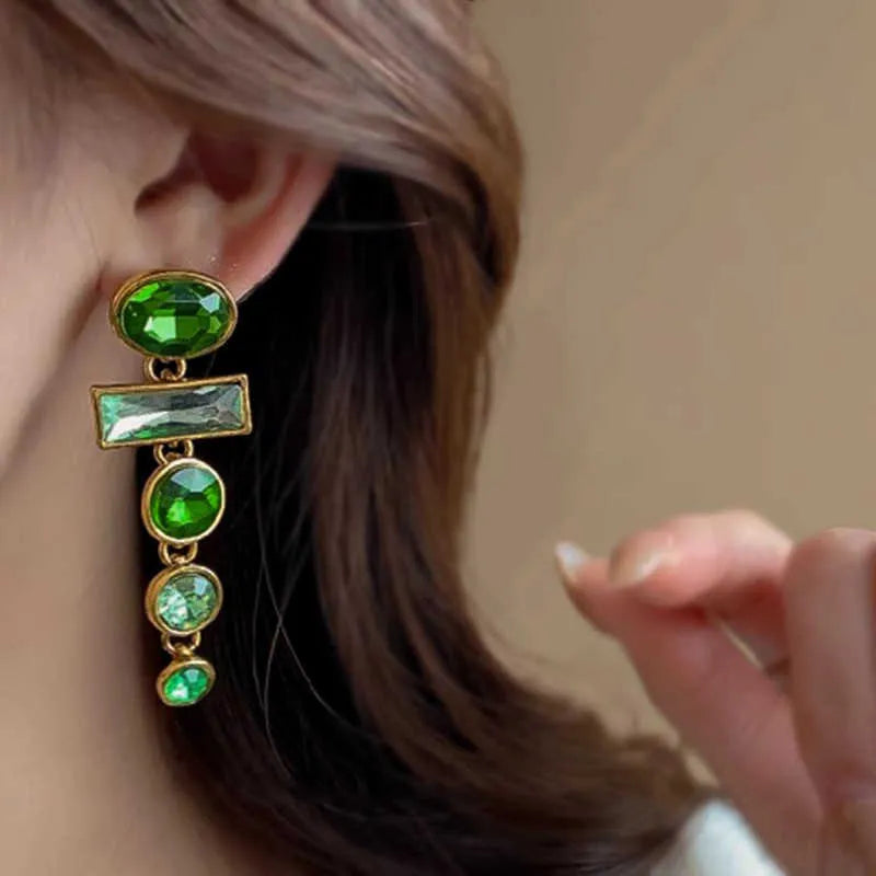 Green gradient tassel drop earrings with geometric alloy shapes and inlaid zircon stones on a white background.