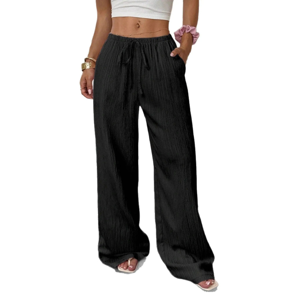 Women's black wide-leg trousers with a front lace-up detail on the waistband, laid flat.