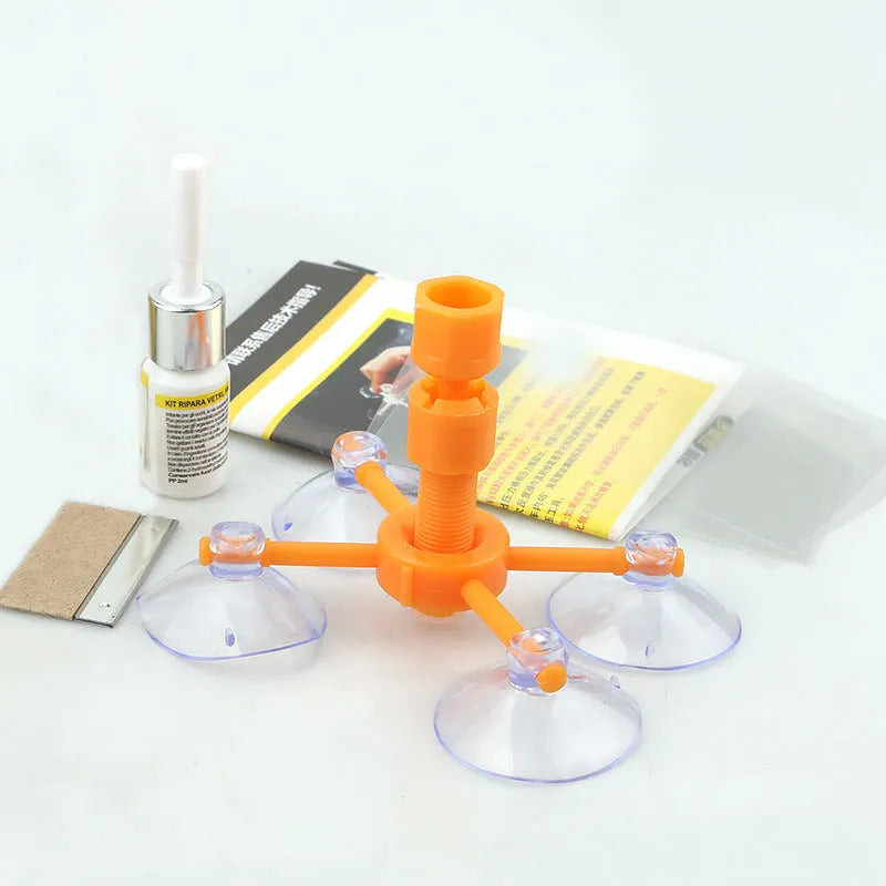 Car windscreen repair kit box containing UV lamp, green resin syringe, injection tools, and yellow bracket.