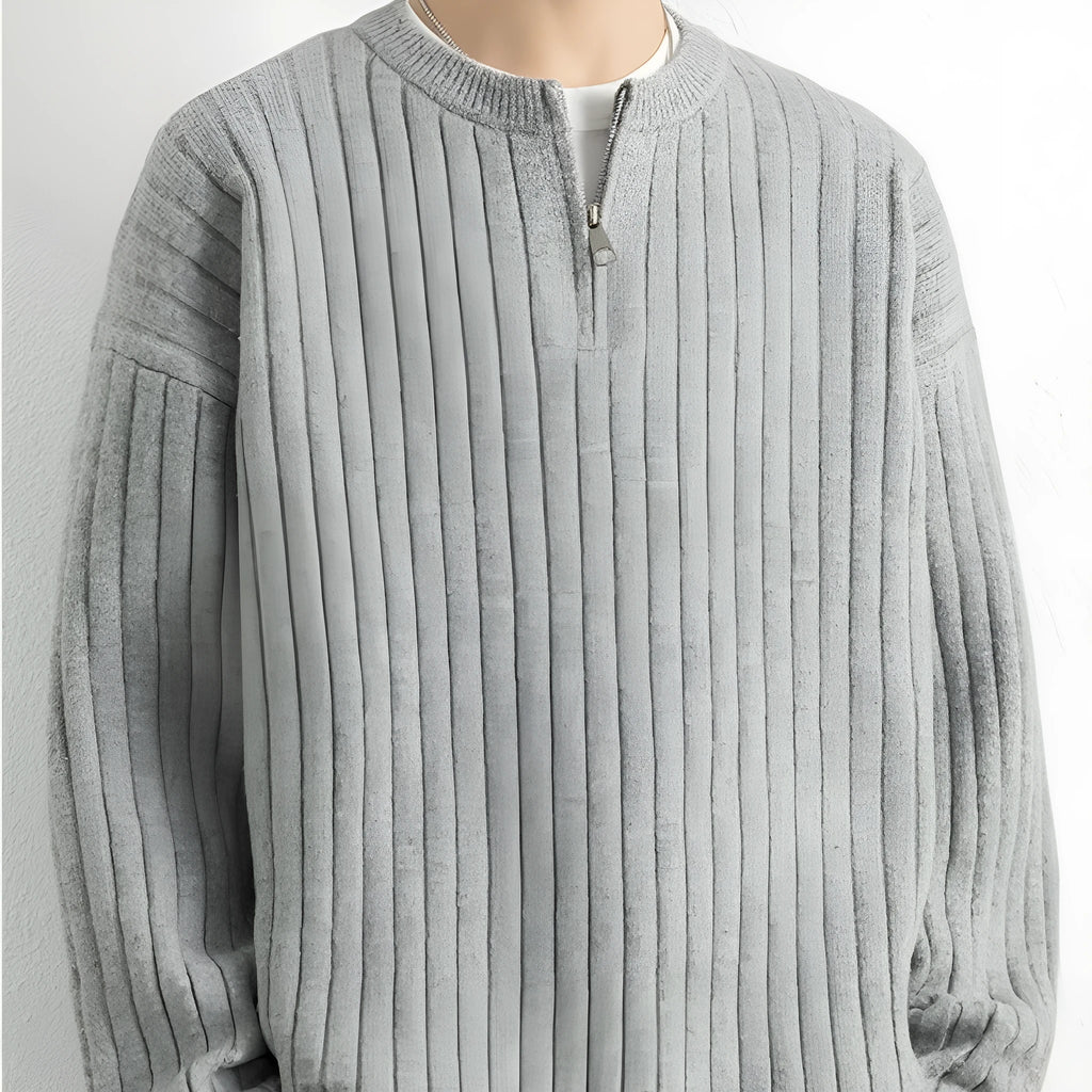 A grey men's loose fit half zip sweater with a textured knit and long sleeves on a plain background.