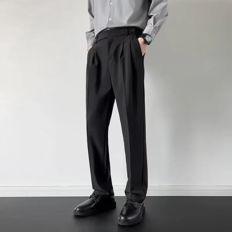 Men's apricot and black straight-leg suit trousers laid flat, showing loose fit and formal design.