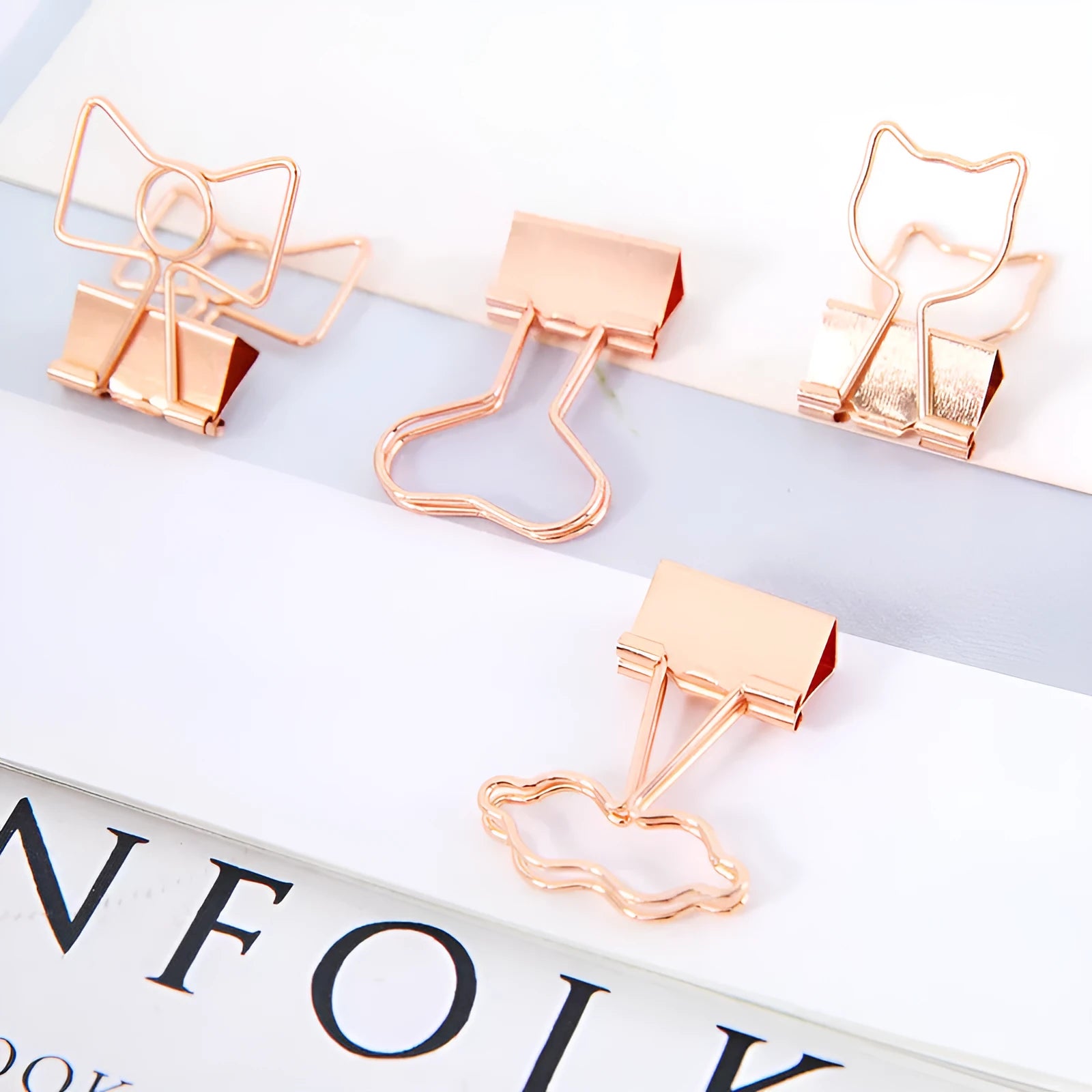 Gold metal paper clip with a long tail, showing decorative flamingo, love, cloud, cat, cactus, and bow motif options.