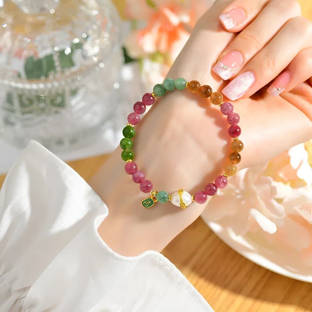 Geometric chalcedony stone bracelet with tourmaline colour beads on a wrist.