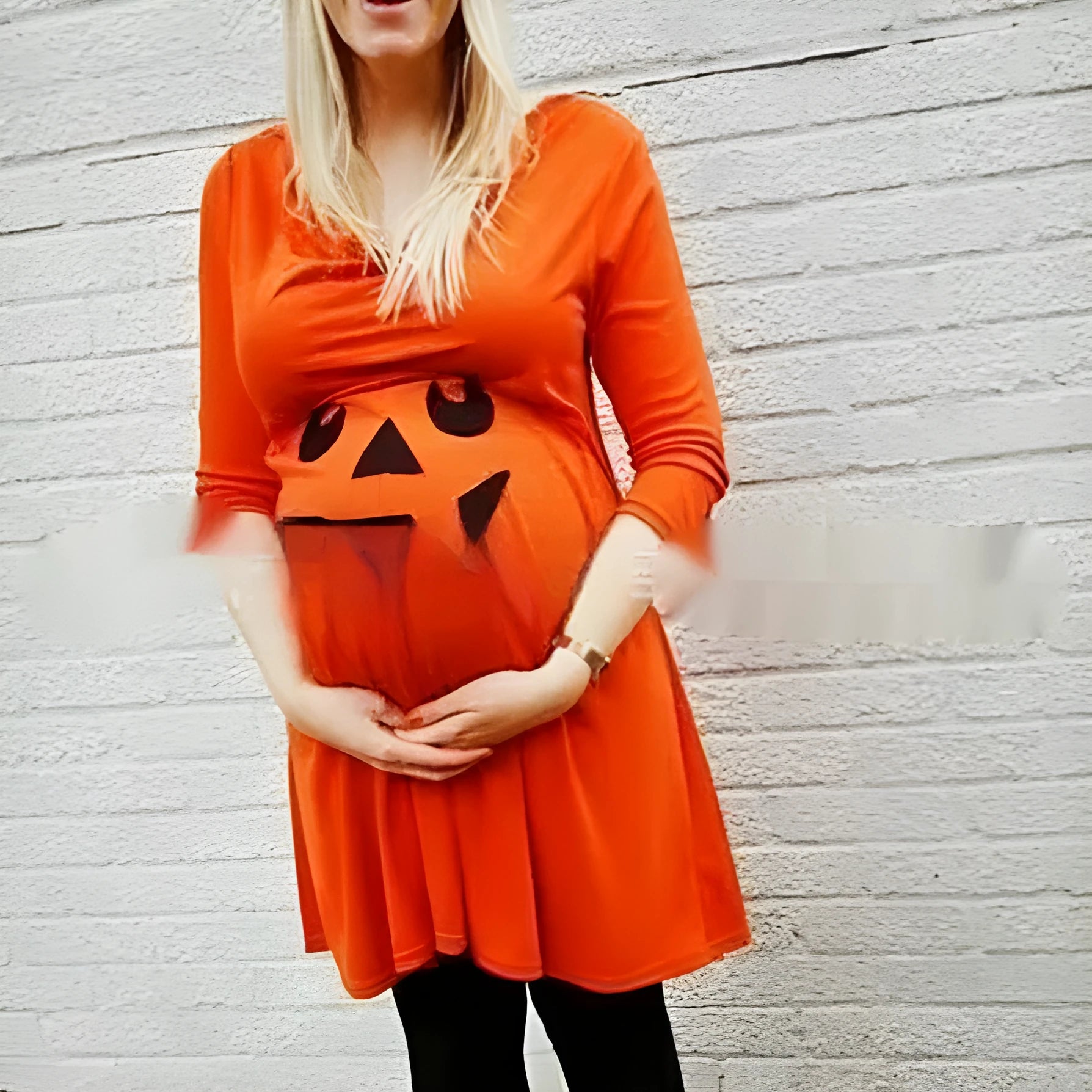 Orange cotton maternity dress on a hanger, showing its simple design and bright colour.
