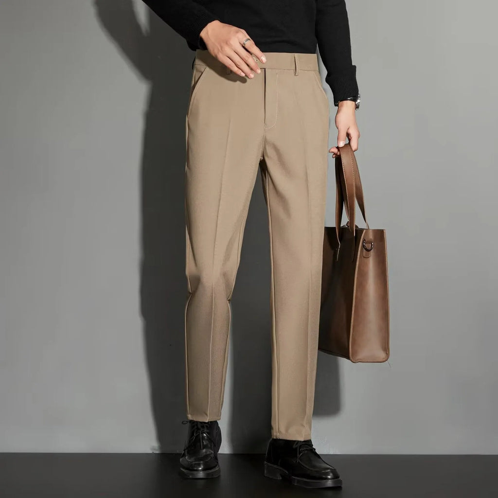 Men's straight-leg ankle-length suit trousers in a light colour showing drape and fit.
