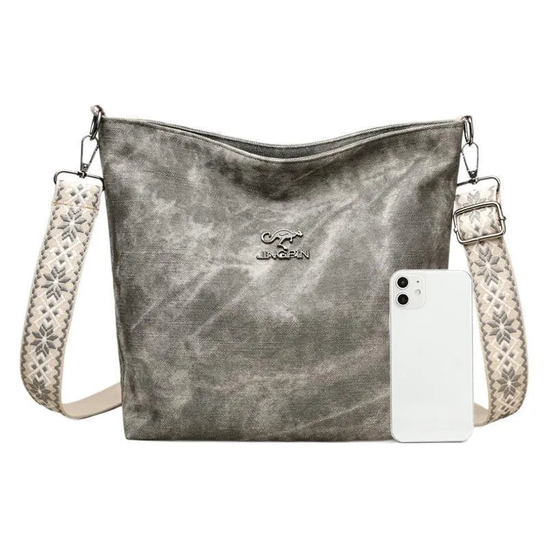 Soft grey PU crossbody bag with adjustable strap on mannequin