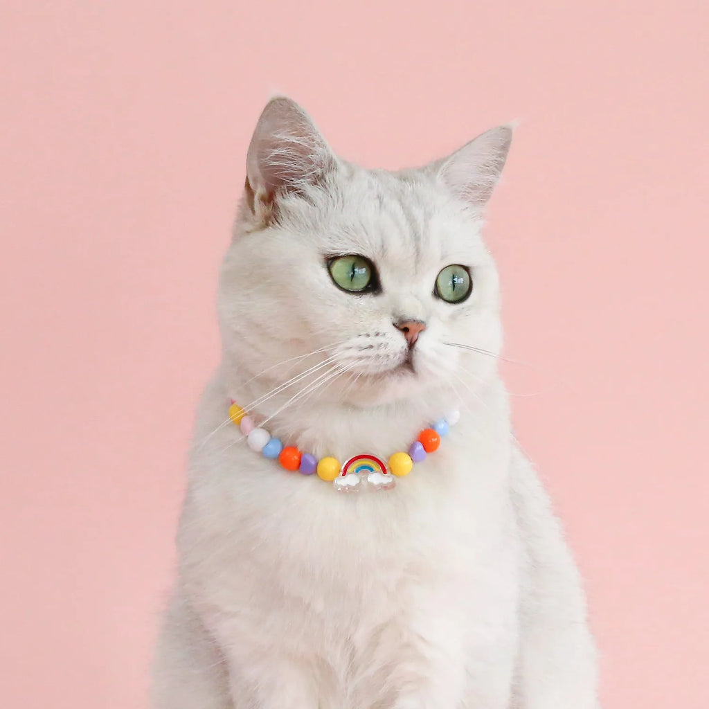 Colourful plastic bead pet necklace for cats in peach, rainbow, or small flower patterns on a white background.