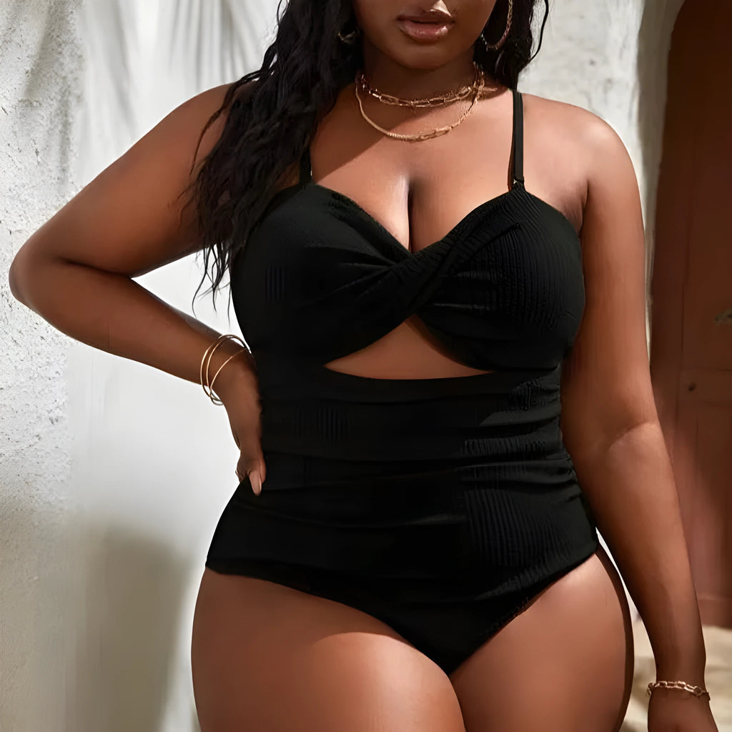 Plus size women's black slimming one-piece swimsuit with triangle sling design