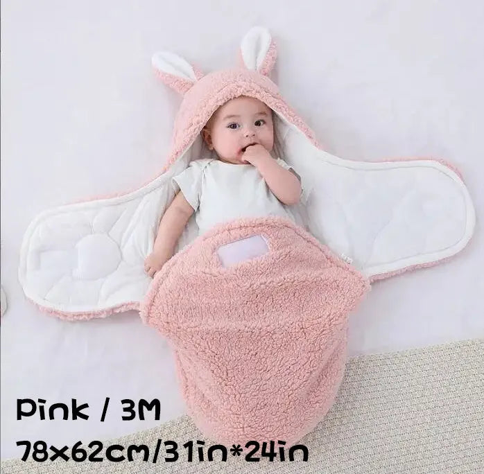 Baby wearing a grey adjustable fleece swaddle sleep sack with velcro wings