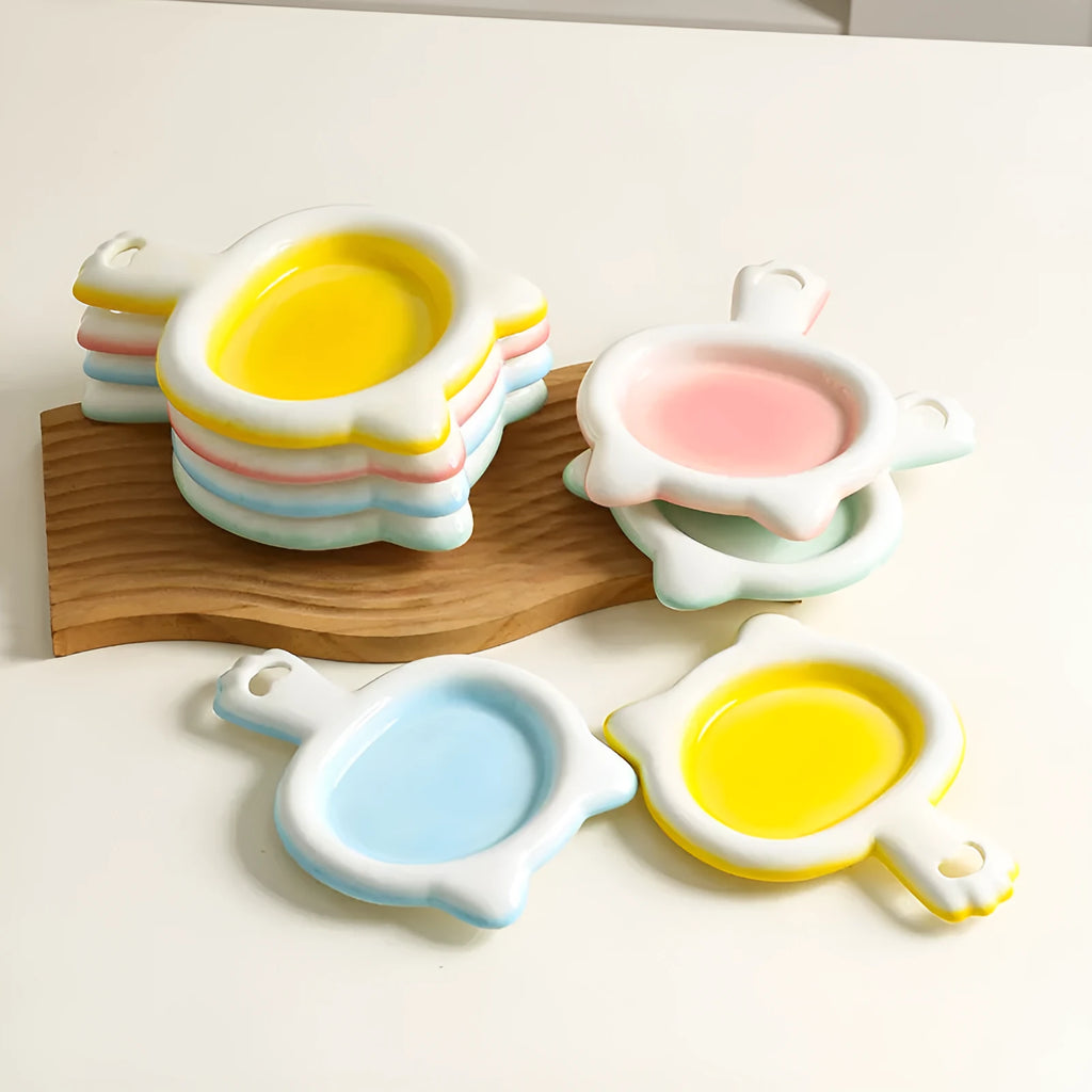 Blue ceramic cat bowl with shallow design for pet food on a wooden surface.