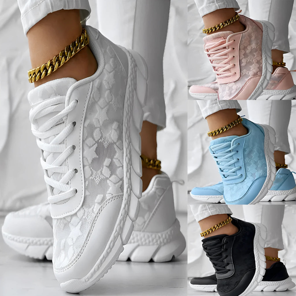 Women's white canvas sports shoes with a flat heel and round toe on a plain background.