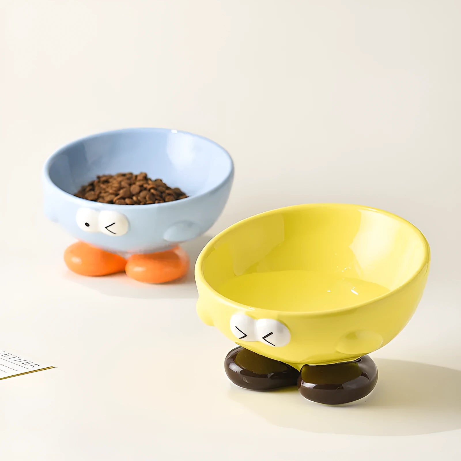 Cute Expression tall slanted ceramic pet food bowl in blue and yellow colours for cats and dogs