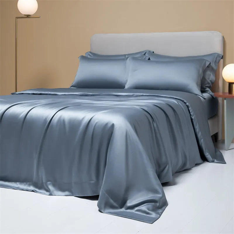 A neatly made bed with a Lenzing Tencel duvet cover and pillowcases in a soft grey colour.