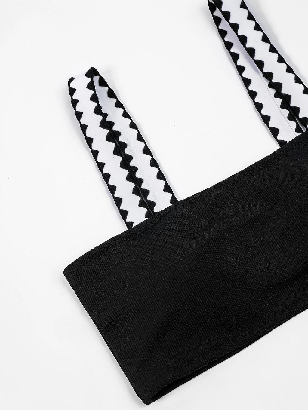 Black women's hollowed-out split swimsuit bikini on a neutral background