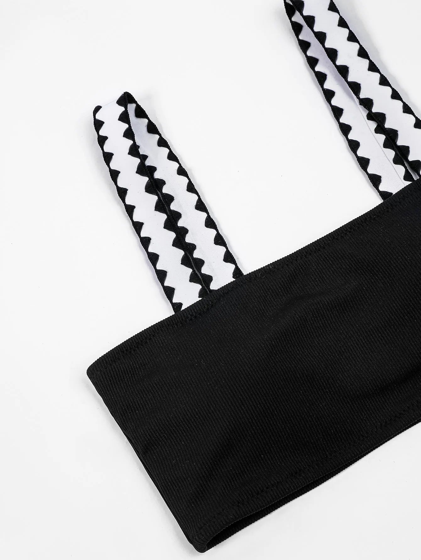 Black women's hollowed-out split swimsuit bikini on a neutral background