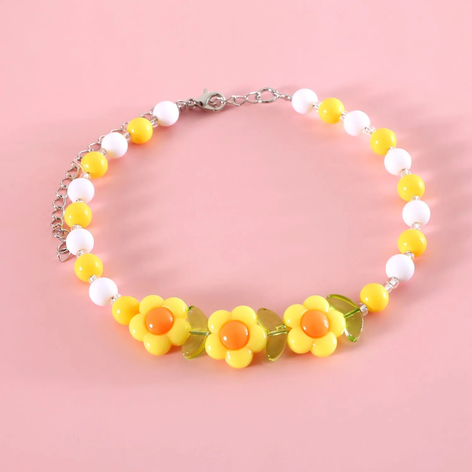Colourful plastic bead pet necklace for cats in peach, rainbow, or small flower patterns on a white background.