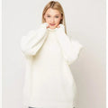 Woman wearing a thick high-neck pullover sweater in a solid colour with a textured 3D pattern.