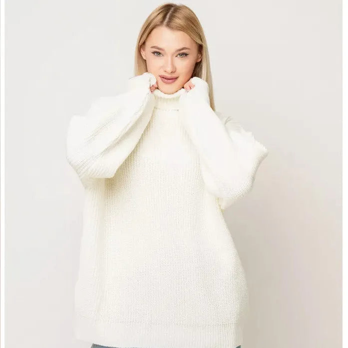 Woman wearing a thick high-neck pullover sweater in a solid colour with a textured 3D pattern.