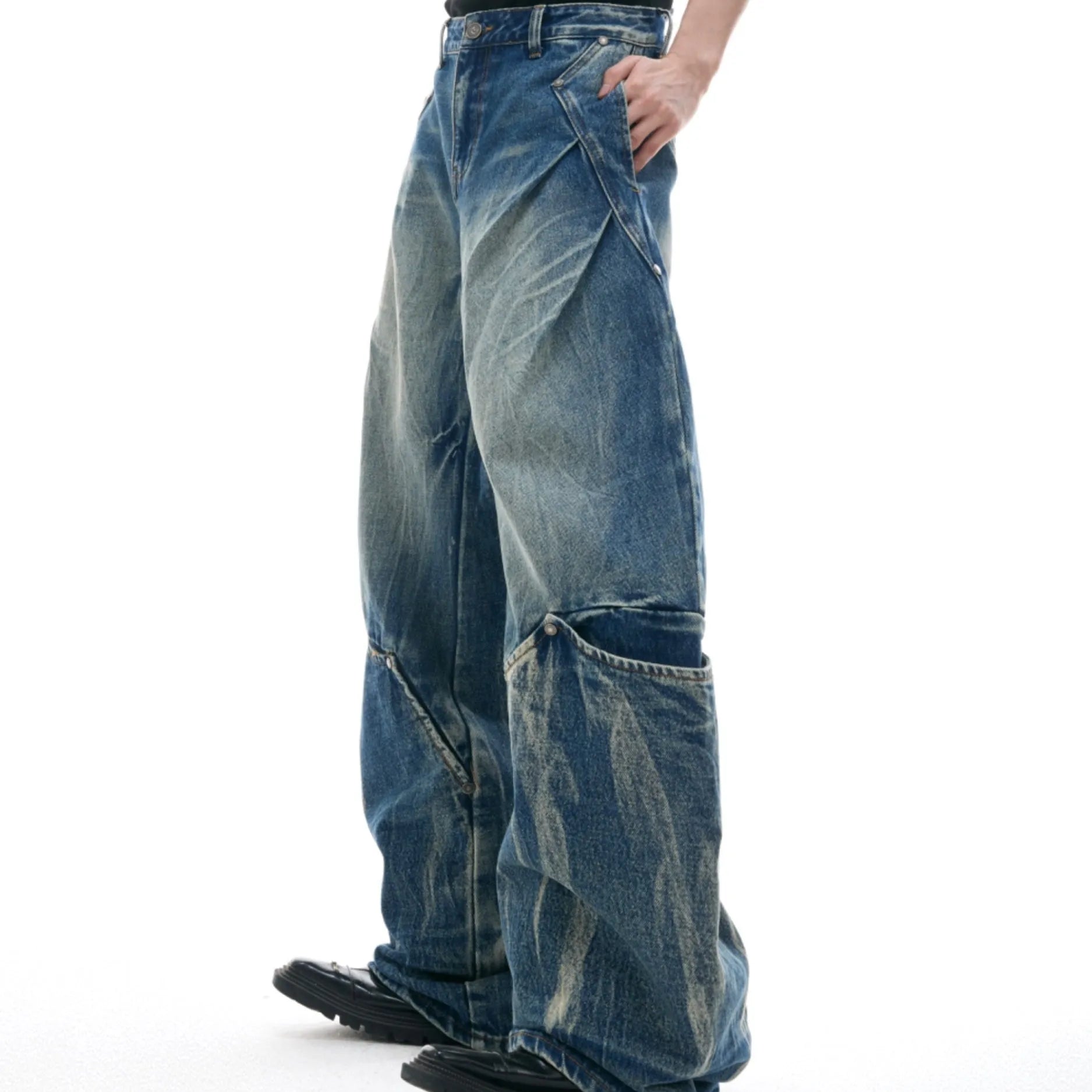 Men's verdant blue loose fit jeans showing curved knife pattern detail and vintage wash on a cotton blend fabric.