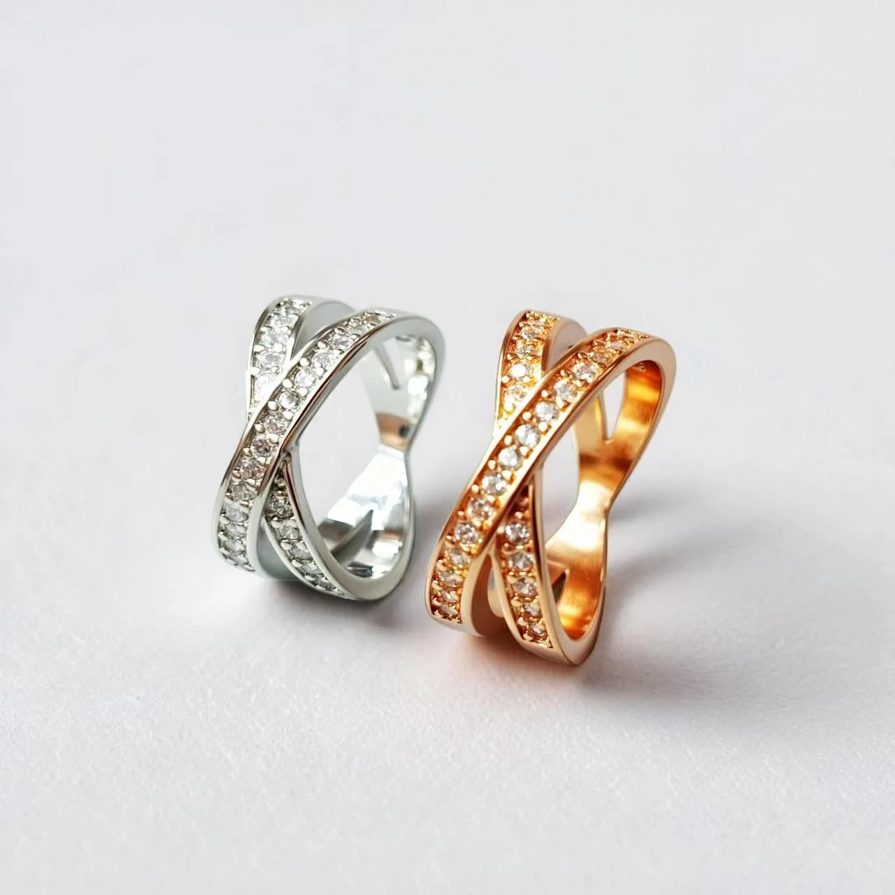 Geometric heart-shaped cross ring with micro-inlaid zircon stones in silver or rose gold finish.