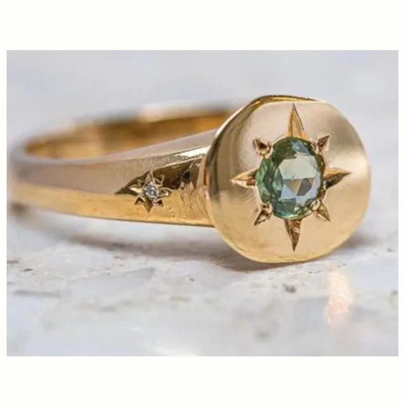 Gold colour adjustable ring with a star-shaped zircon stone set flush into an oval zinc alloy band.