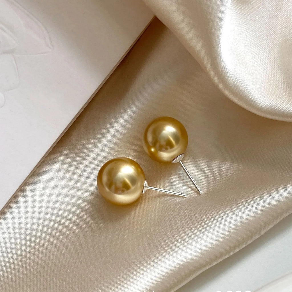 Close-up of a women's large pearl stud earring with an eight-point geometric silver star setting.
