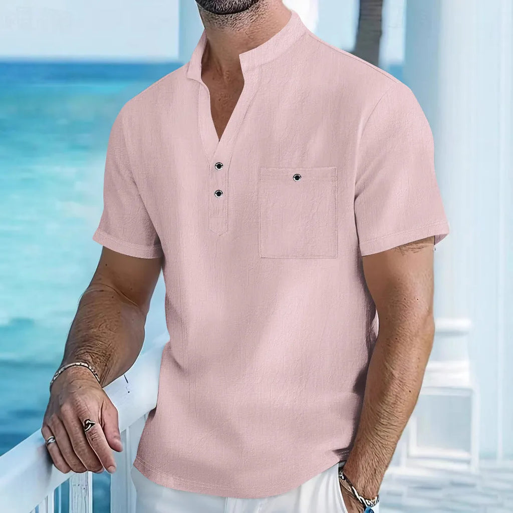 Man wearing a loose apricot-coloured linen stand collar T-shirt with short sleeves.