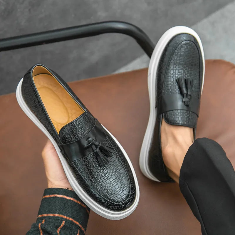Men's black casual leather shoes with fringe detailing on the upper, round toe, and low heel.