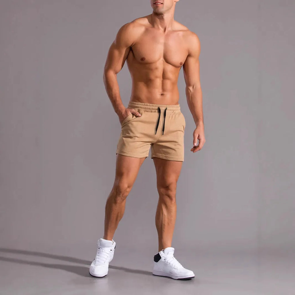 Pack of three men's solid colour drawstring shorts in black, khaki, and light brown on a hanger.