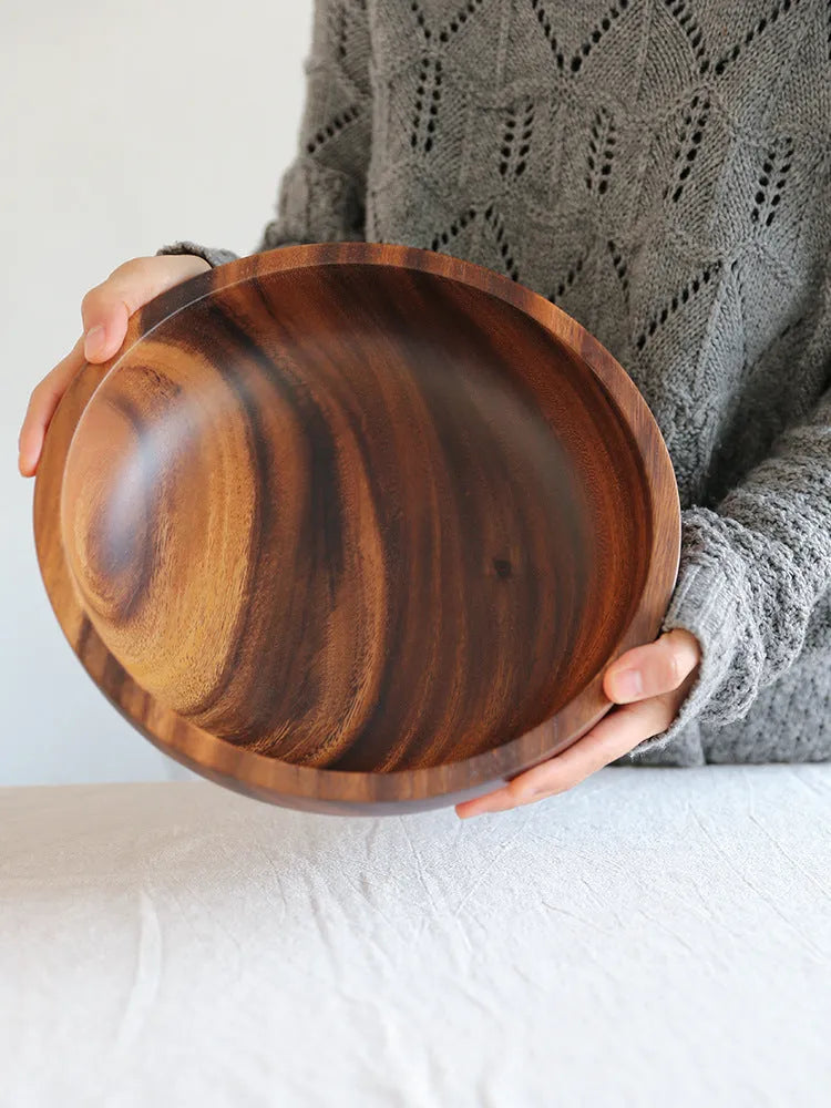 Handmade brown wooden bowl set showing multiple sizes from small to large on wooden table