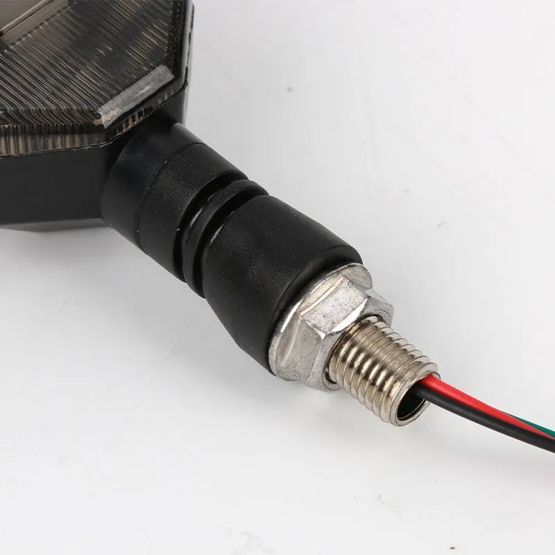 Arrow-shaped LED motorcycle turn signal light with 12V label and ABS plastic housing.