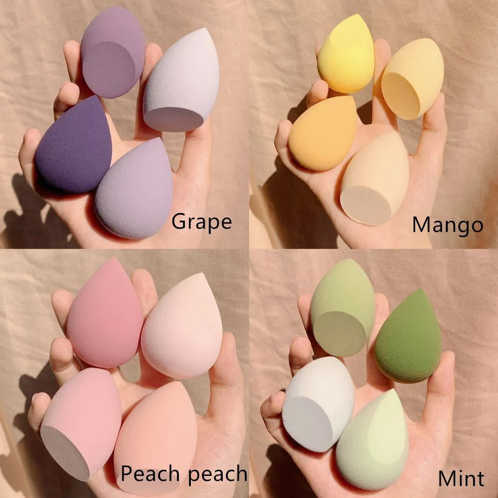Set of four colourful egg-shaped makeup sponges in Grape, Mango, Mint, and Peach Peach.