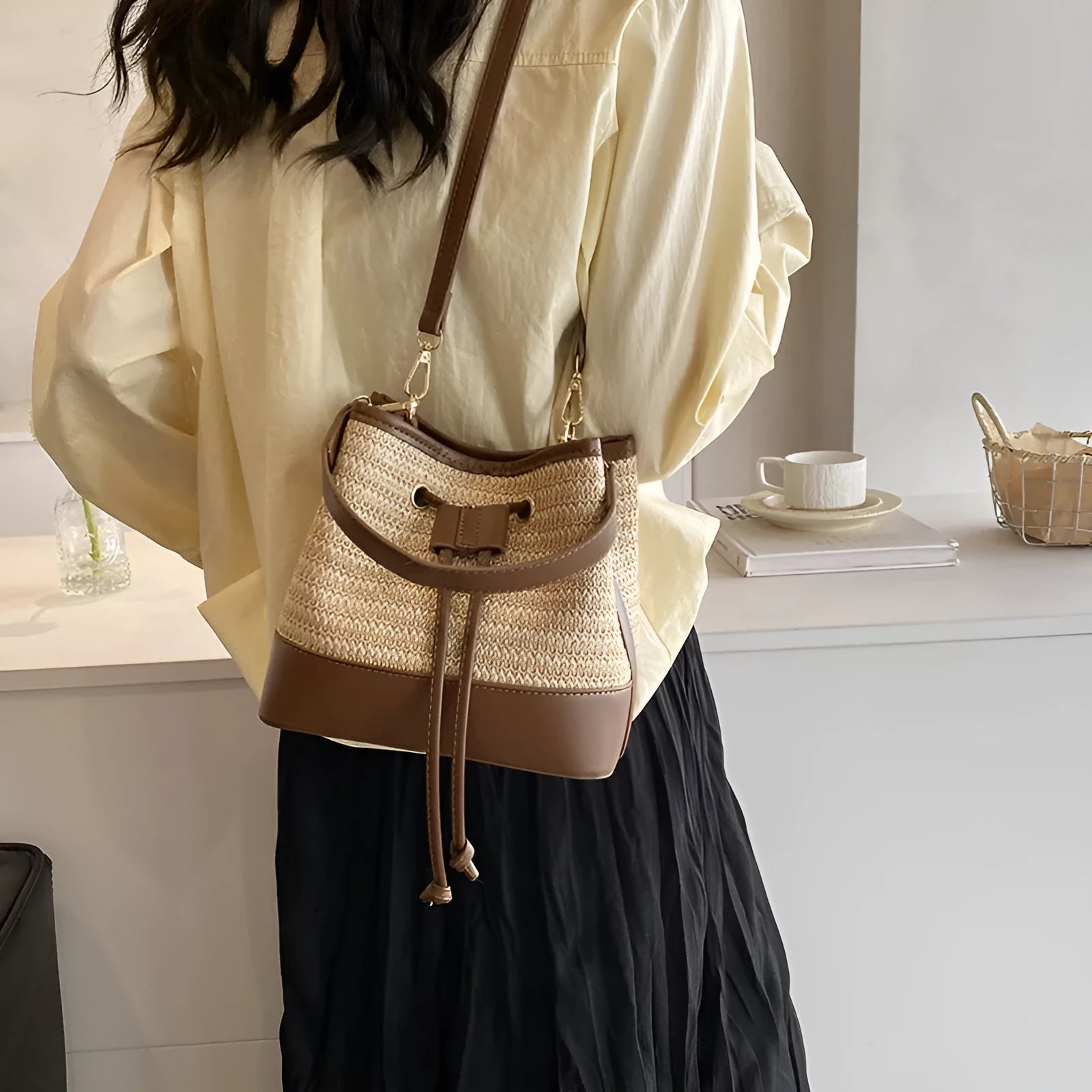 Woven straw women's crossbody bucket bag in brown colour showing horizontal square shape