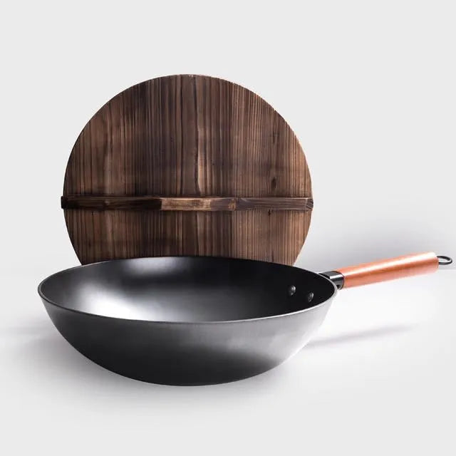 Black handmade traditional iron wok with a long wooden handle, shown with a glass lid.