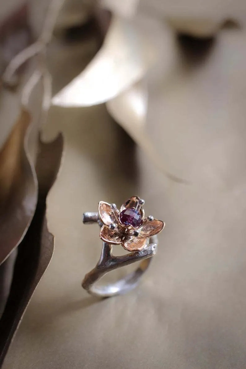 Silver two-tone floral geometric alloy women's ring on a plain background.