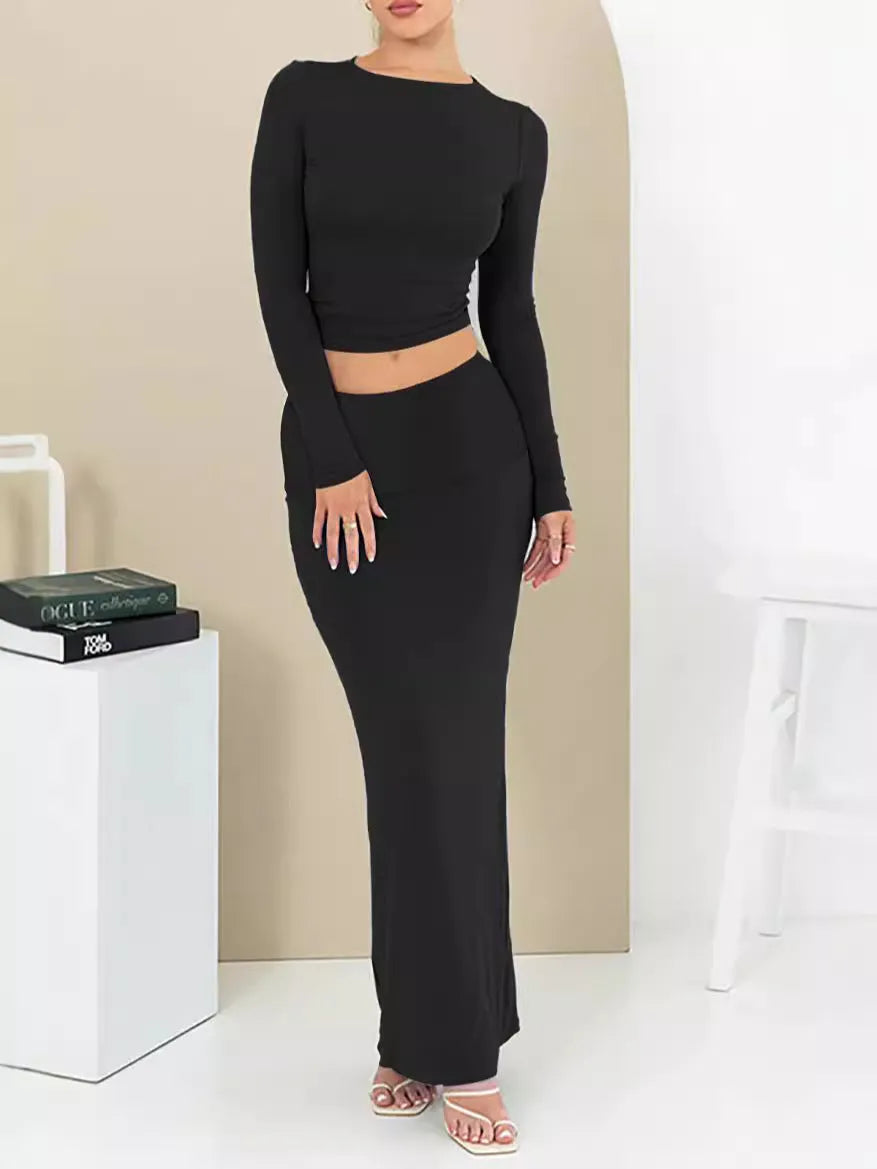 Women's black slim fit two-piece suit with exposed navel top and long skirt.