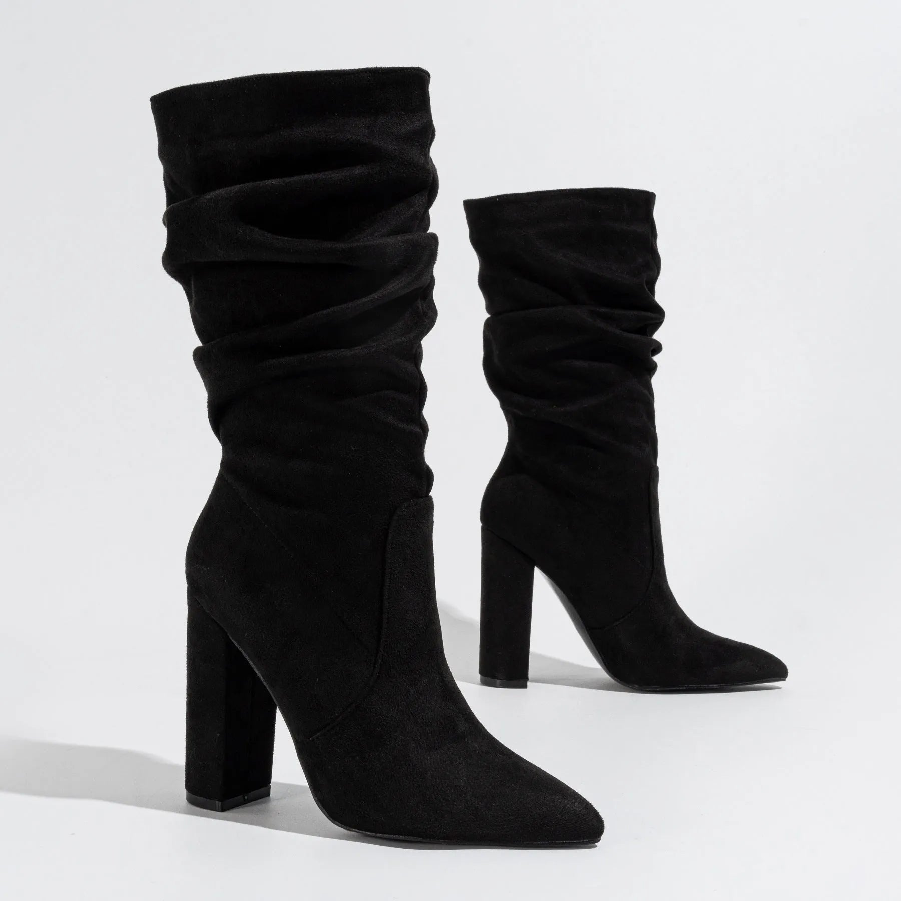 Women's black suede chunky heel pointed toe ankle boots with a high heel, shown from the side.