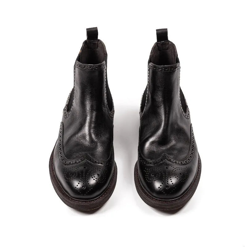 Men's black Chelsea boots with brogue carved genuine leather upper and rubber sole, side view