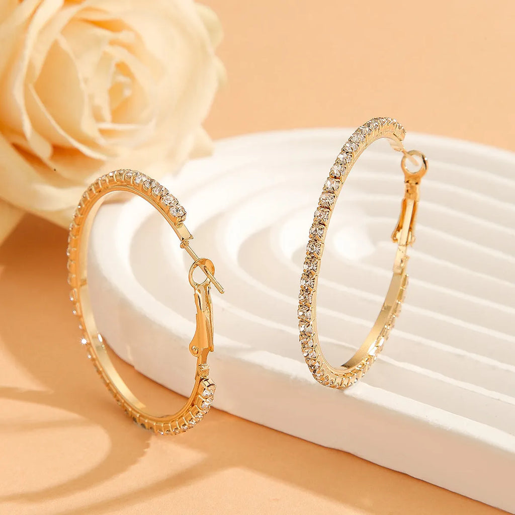 Large gold plated copper zircon hoop earrings for women, princess style, gold colour, on white background