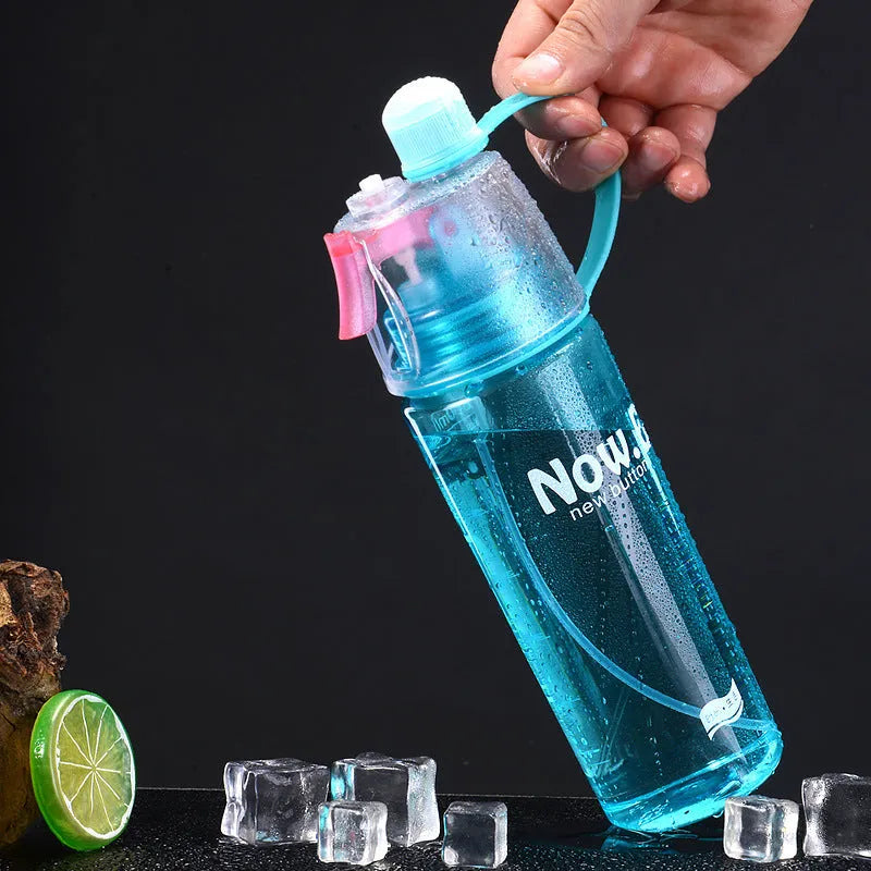 Green portable sports mist spray cup with transparent body, scale markings, and a black spray mouth cap.