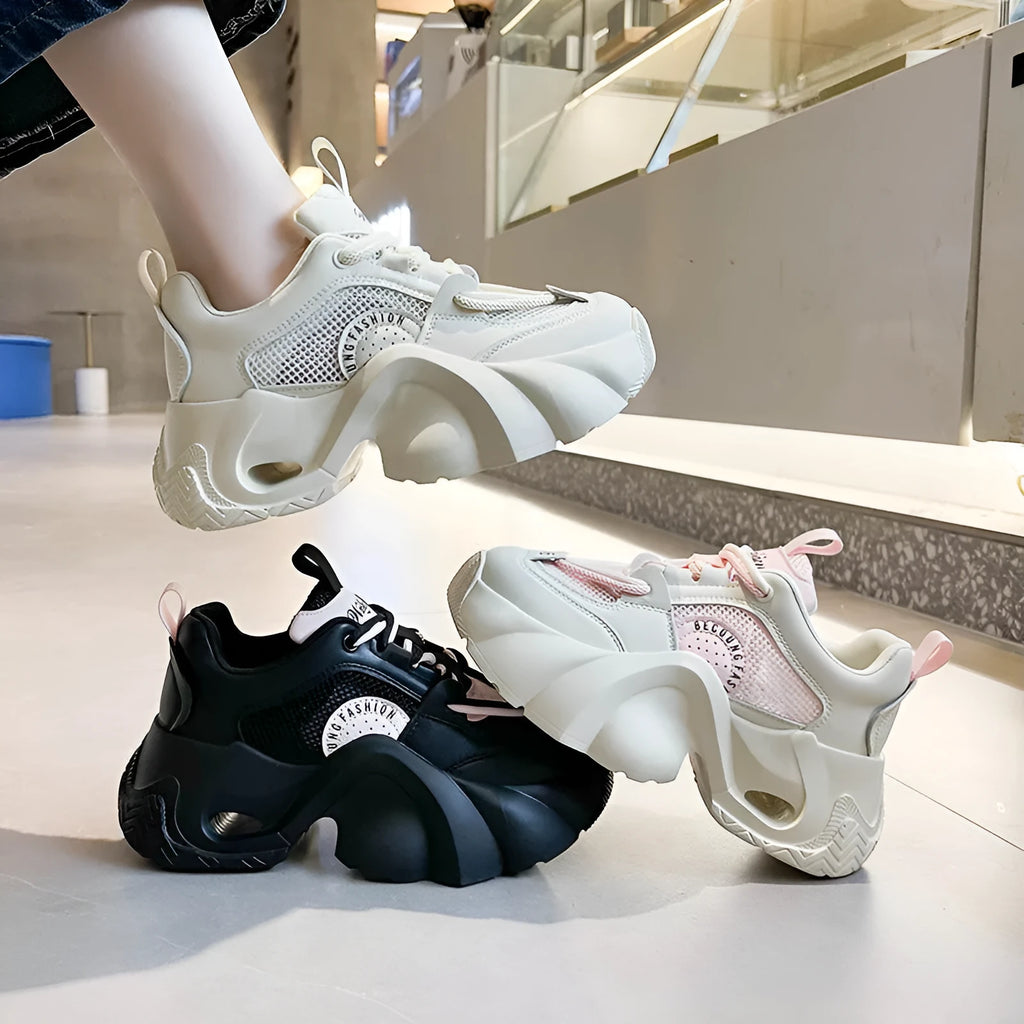 Women's pink casual sneakers with a thick sole, cross-strap detail, and lace-up closure on a white background.