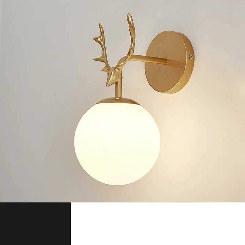 Round clear glass wall lamp with a minimalist design mounted on a light-coloured wall, emitting a soft, diffused warm white glow.