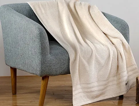 Beige and brown cotton towel set showing bath towel, hand towel, and face cloth sizes